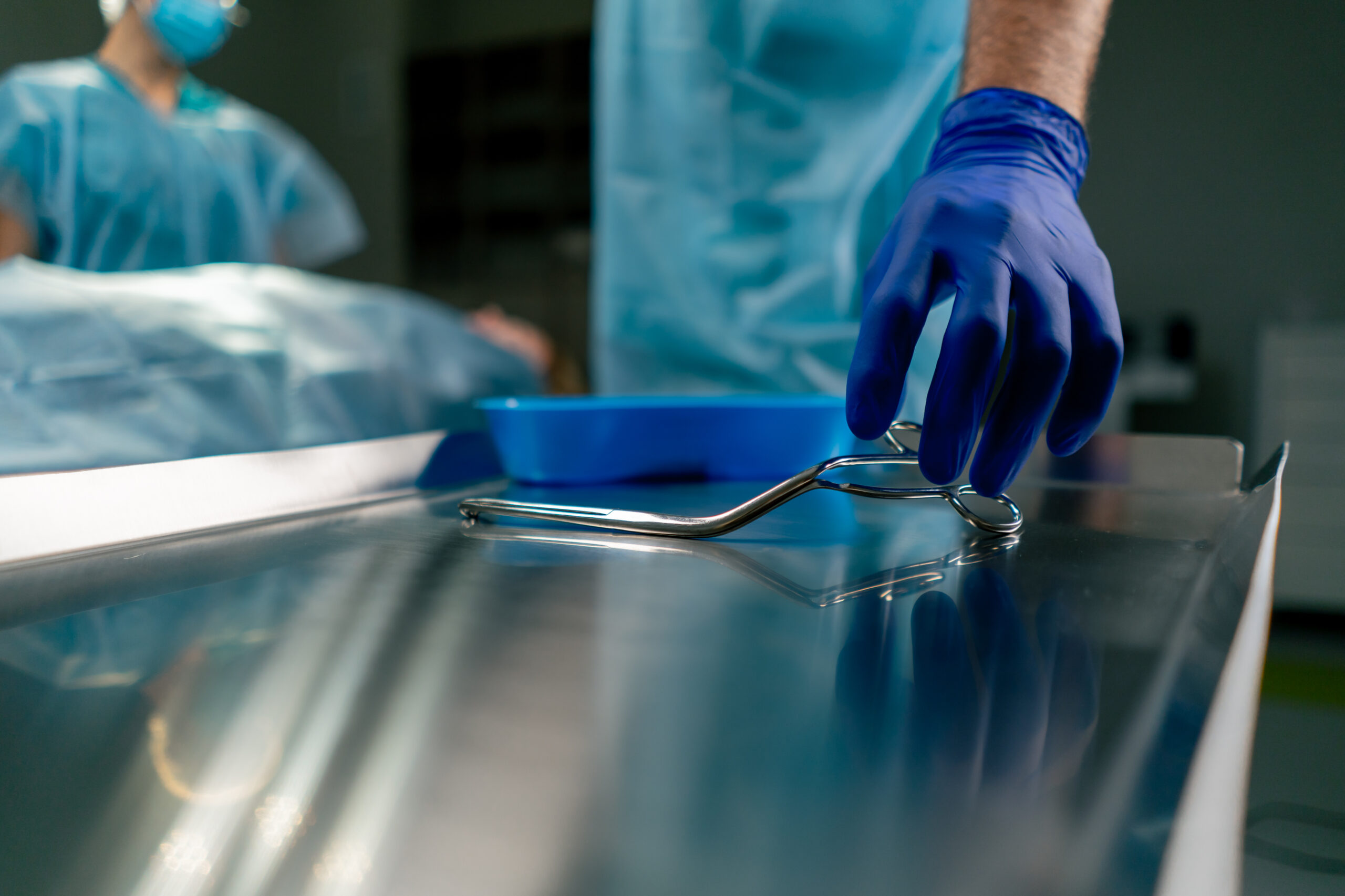 Close-up shot of sterilized scalpels and other metal instruments for surgery on a table in an operating room