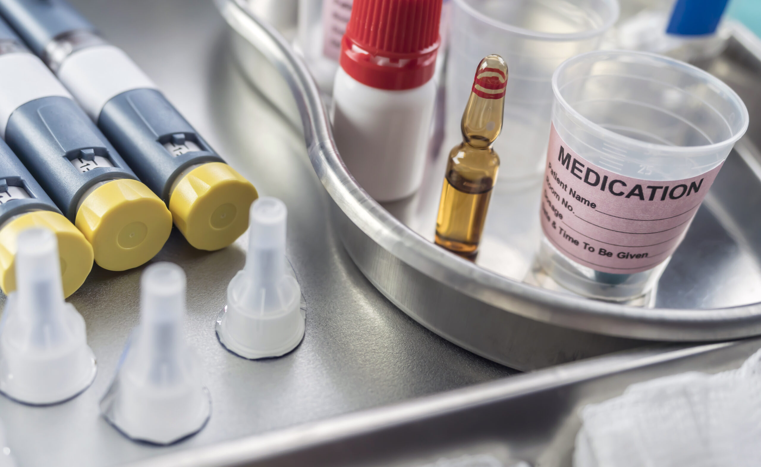 Syringes of insulin medication next to medicine vials prepared in hospital, conceptual image,